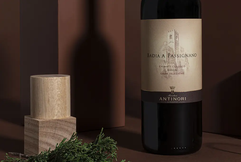 A bottle od Badia a Passignano wine beside greenery and wooden decor.